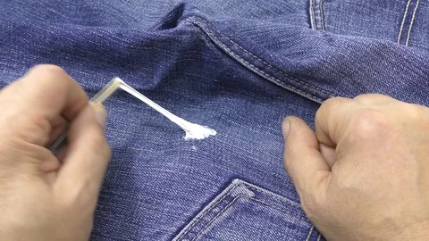 Man is trying to remove chewing gum adhering to jeans. Stock Footage 118794552