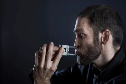 Man trying to rip off padlock from lips. Stock Photos