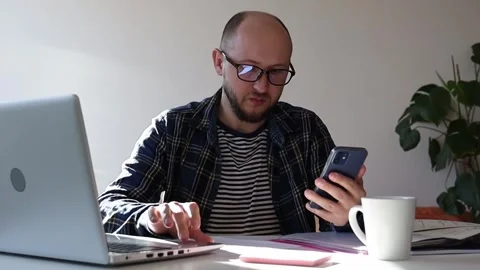 Man is trying to sort out accounts and get through to the bank. Stock Footage 244008146
