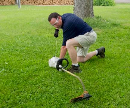 Man Trying To Start A String Trimmer Stock Photos