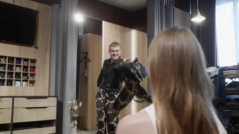 Man trying stylish clothes while showing female partner in fashion store Stock Footage 303459473