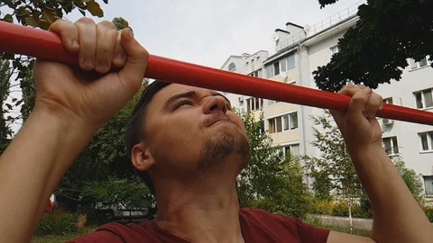 Man trying very hard to complete pull up overcoming pain, achieving success Stock Footage 94907101