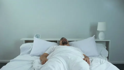 Man trying to wake up in morning, problems with sleep, chronic fatigue syndrome Stock Footage 91562802
