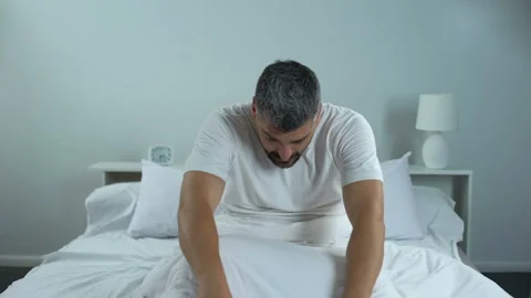 Man trying to wake up in morning, problems with sleep, chronic fatigue syndrome Stock Footage 91565327