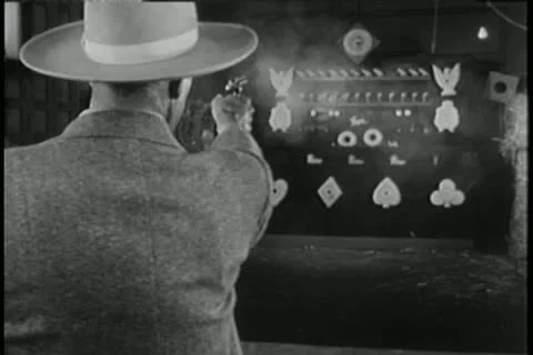 Man trying to win prize at  carnival shooting gallery Stock Footage 14521275