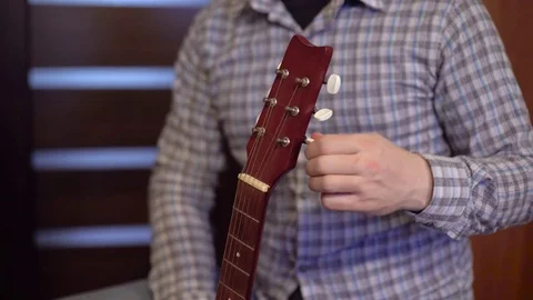 Man  tunes guitar strings Stock Footage 73751824