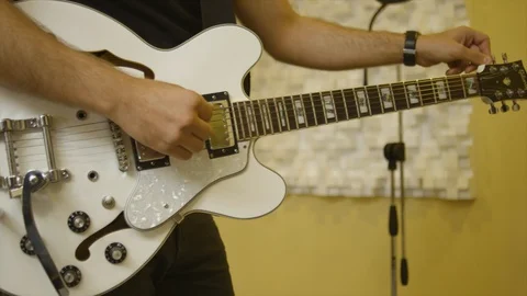 Man Tunes His Guitar while pianist is playing on a rehearsal Stock Footage 109460892