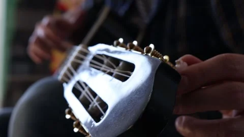 Man tuning guitar before playing. Stock Footage 244878251