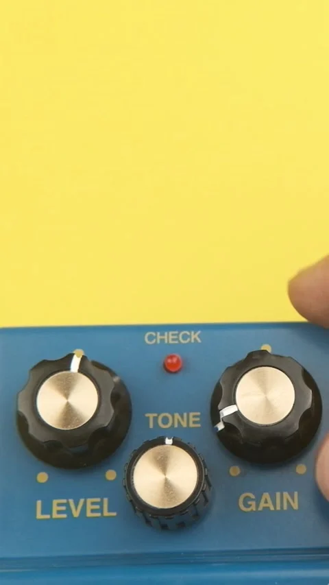 Man tuning knob volume up on guitar pedal effect isolated on yellow Stock Footage 246264644