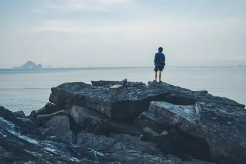Man turned back to the camera looking at the sea, relaxed, concept of freedom Stock Photos