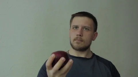 Man turning apple and thinking. Video stock 77325132