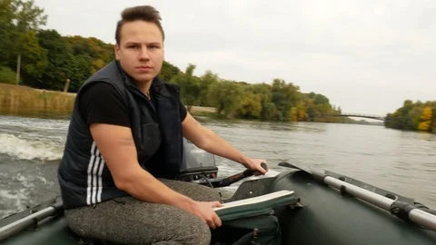 Man turning around on an inflatable motor boat Vídeos de archivo 117673756