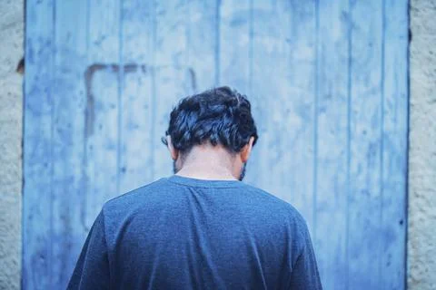 Man turning back to camera feeling alone. Rear view of thoughtful man feeling Stock Photos