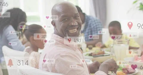 Man turning to camera, smiling with fork, causing alerts surging over family Stock Photos