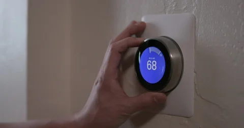 Man Turning Down Temperature of Smart Thermostat Gadget At Home - Medium Video stock 91516819