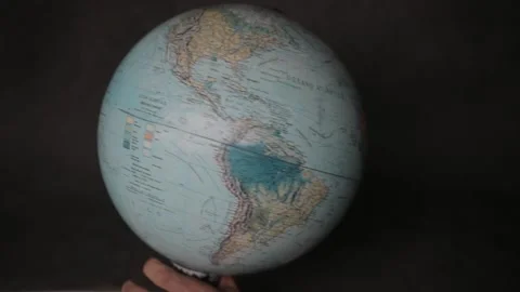 A man turning a globe around with his hand and pointing to portugal and Italy Stock Footage 163773887