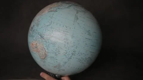 A man turning a globe around with his hand and pointing to arab peninsula and no Stock Footage 163773898
