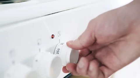 Man turning on the oven switch, knob and button in home kitchen. Stock Footage 104855027