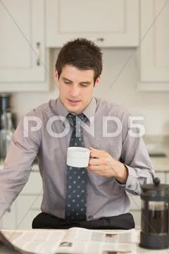 Man turning the page while drinking coffee Stock Photos