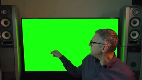 Man turning to point to a large green computer screen Stock Footage 167167308