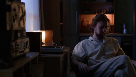 Man Turning on Vinyl Record Player for Relaxing at Home in Evening Stock Footage 345516223