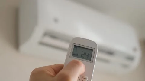 Man turns on air conditioner with remote control, close-up Stock Footage 295063115