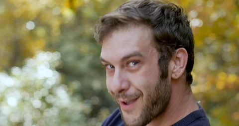Man turns and looks at the camera with a goofy mischievous smile Stock Footage 101446434