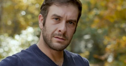 Man turns and looks at the camera nodding his head with a serious confident look Stock Footage 101446604