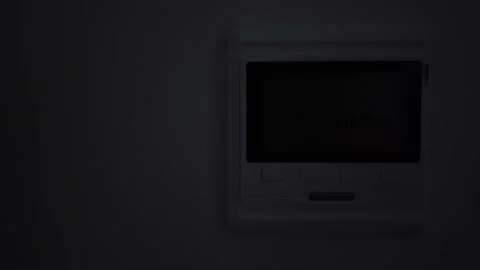 Man turns on and regulates the temperature of the warm floor on the regulator Stock-Footage 122099508