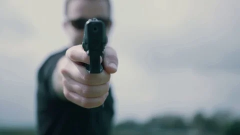 Man turns around and points gun at camera Stock Footage 71996751