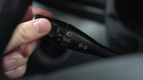 A man turns on the dipped headlights by turning the lever in the car. Automotive Stock Footage 198598415
