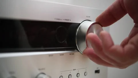 A man turns down the volume on an audio device's control panel. Video stock 298037764