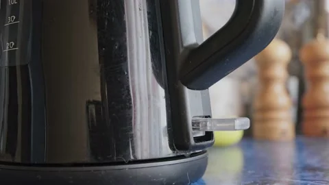 Man turns on an electric kettle Stock Footage 163991312