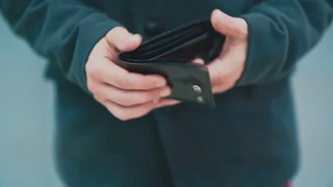 Man turns an empty wallet in his hand Stock Footage 77187602