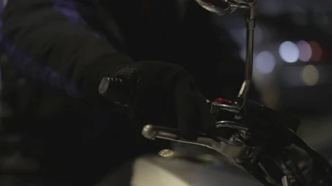 Man turns the handlebar in motorcycle for start engine move on night street Stock Footage 76878635
