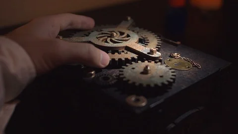 A man turns his hand one of gears and sets in motion whole mechanism. Stock Footage 105861376