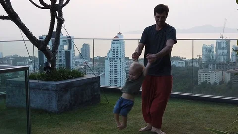 A man turns his two year old child outdoors Stock Footage 104949899