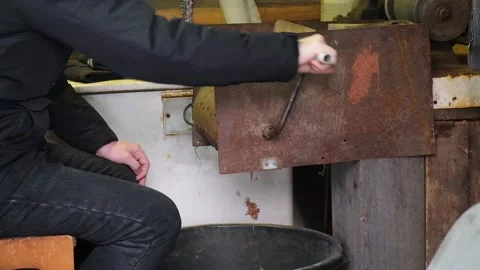 A man turns homemade device for extracting cedar nuts from Siberian pine cones. Stock Footage 177372103