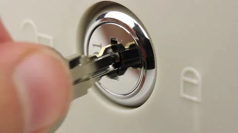 Man turns the key in the lock several times, opens and closes lock, close-up Video stock 145535914