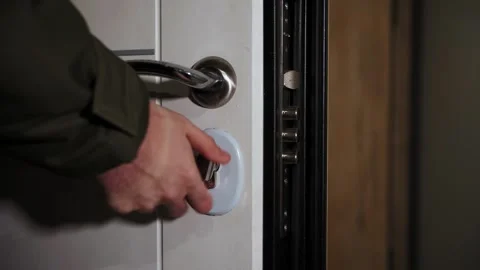 Man turns the latch on the door Stock Footage 168581294