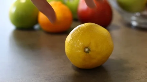 The man turns lemon with his hand. Movement and stop of fruit. Fresh vitamins. Stock Footage 112939532