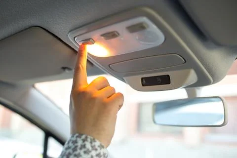 The man turns on the light on the ceiling in the car Stock Photos