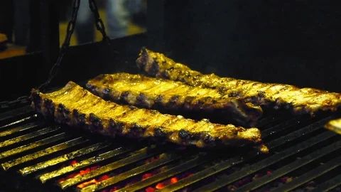 The man turns the meat ribs, which are roasted on the grill Video stock 84252771
