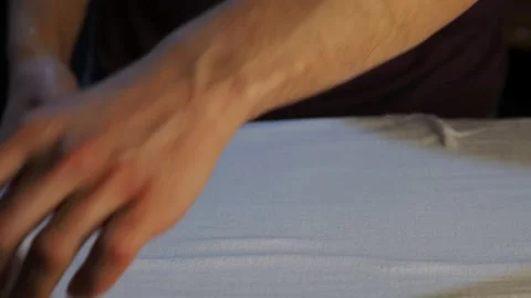 A man turns over a white pillowcase on an Ironing Board Stock Footage 130633470