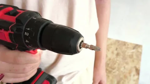 A man turns on a power drill with a drill. Cordless screw driving tool Stock Footage 322894500
