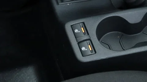 The man turns on the seat heating in the car Stock Footage 168103003