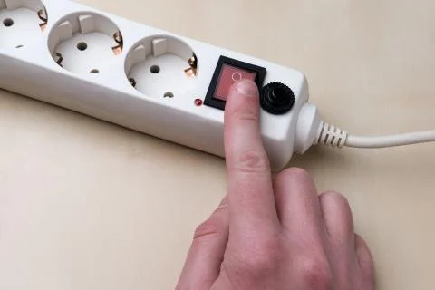The man turns on the socket with his finger. Stock Photos
