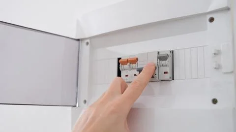 Man turns on toggle switch with hand closeup Stock Photos