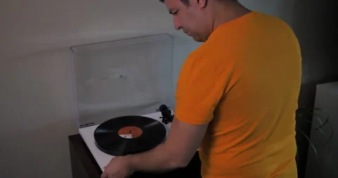 Man turns off turntable, puts record in sleeve, and puts it away. Stock Footage 140265277