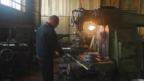 Man turns valve of milling machine to fix detail at factory Stock-Footage 243306834